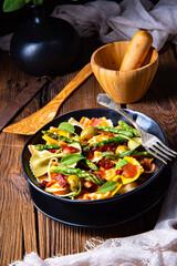 Pasta salad with green asparagus, olives and parma ham