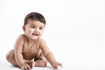 Indian baby girl playing on white background.