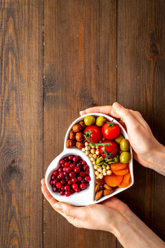 Hands with heart shaped dish of healthy diet food