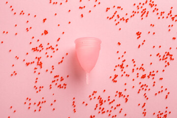 Reusable menstrual cup and blood drops symbol on pink, menstruation woman product, feminine hygiene