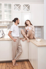 Couple in love having breakfast in the kitchen, multinationality