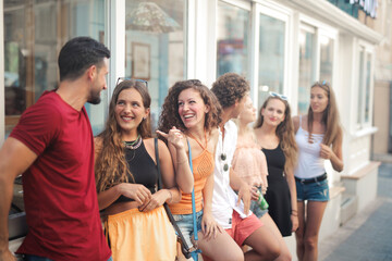 group of young people talk and laugh in the street