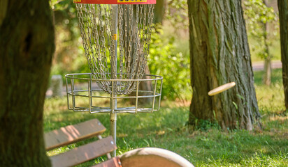 Disc golf basket with bench and shooting disc