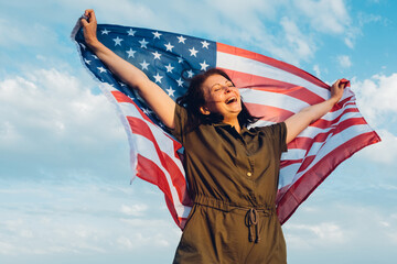 Happy middle aged woman holding american flag.