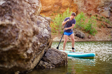 The guy on the sup board on the lake. Fitness recreational leisure activity. Beach rental equipment...