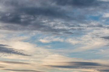 Obraz premium clouds formation across a winter sky with soft pastel sunset tones and different shapes of clouds