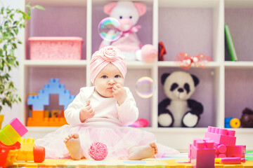 baby playing with colourful building blocks at home or kindergarten