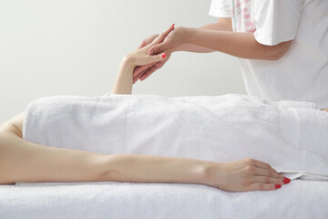 Obraz premium Arms massage. Young Caucasian woman enjoing soft shooting partial relax massage experience at spa salon.