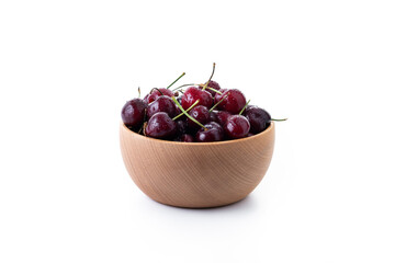 Fresh cherries with water drops in wooden bowl isolated on white background