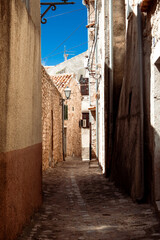 Old narrow street of historic town Omišalj on coast of Adriatic sea on Croatia island Krk