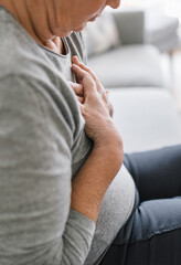 Elderly woman with heart pain holding her chest