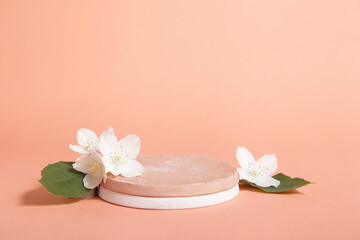 Minimal cosmetic background for product presentation. Cosmetic bottle podium and flower on Pastel coral color background.