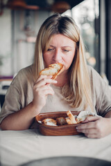 Upset woman dealing with negative emotions, anxiety eating bread. Foods and stress eating concept.