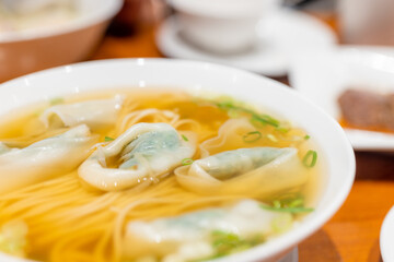 Meat and vegetable dumpling noodles soup bowl in restaurant