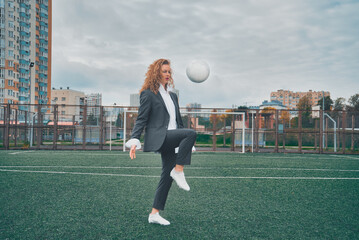 woman soccer player in an office suit stuffs the ball with her head. concept