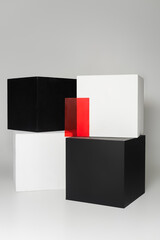 black and white cubes near red glass on grey background.