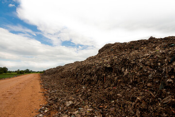 A huge pile of plastic waste in the sun and the blue sky.
