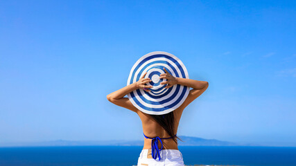 Happy a holiday in Summer blue trend with young woman in hat at  happy freedom lifestyle in Aegean sea mediterranean at Santorini,greece - obrazy, fototapety, plakaty