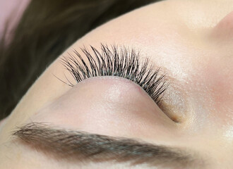 The procedure of classical eyelash extension. Eyelash extension close-up