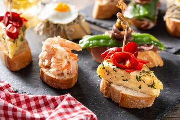 Assortment of Spanish pintxos on wooden table	