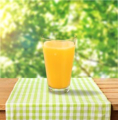 Orange Juice on a color background, in bright light. Glass of Juice with blended orange. Summer...
