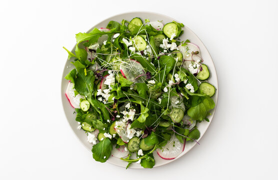 Delicious light salad with cucumbers and arugula, feta and microgreens, radishes and dill