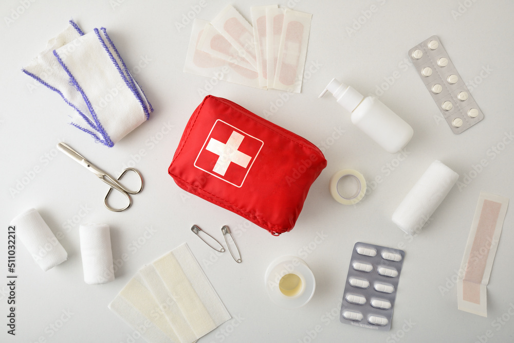 Wall mural Assortment of emergency first aid kit objects on white table.