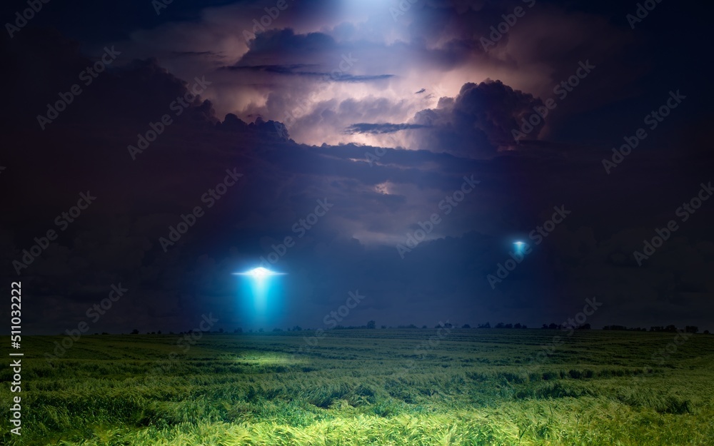 Wall mural scenic sci-fi image: ufo or alien spacecraft inspect green grass field with bright spotlight in dark