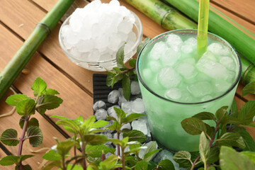 Iced mint drink on wooden table and plant elevated view