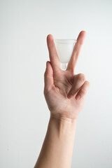 Naklejka premium the woman holds a menstrual cup in her hands 