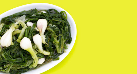 Pickled spring onion in white plate on green background.