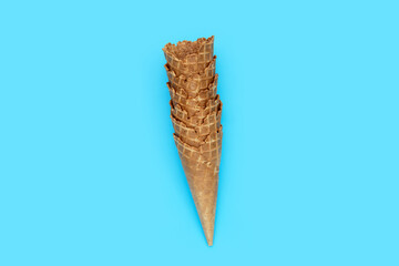 Empty ice cream cone on blue background.