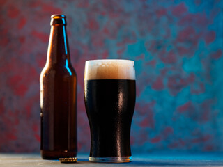 glass of dark porter or stout beer on a blue background. Craft beer concept - obrazy, fototapety, plakaty