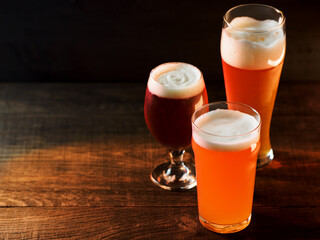 Three pints of a glass of craft or draft beer in the bar on a wooden table. Different beers on the table, copy space
