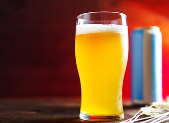 A glass of cold unfiltered wheat beer from a can on the table with copy space.