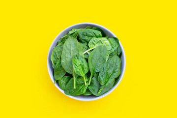 Spinach leaves on yellow background.