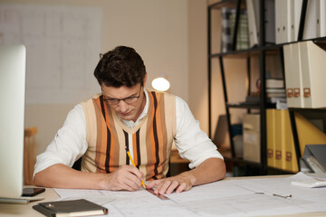 Architect concentrated on drawing construction plan of office building for big company