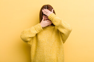 young adult pretty woman covering face with both hands saying no to the camera! refusing pictures...