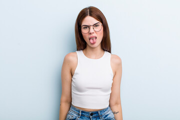 young adult pretty woman feeling disgusted and irritated, sticking tongue out, disliking something...