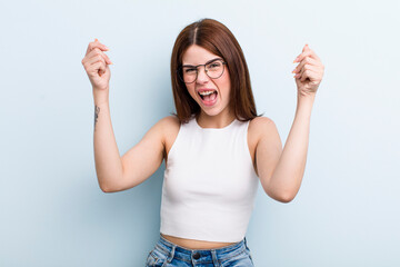 young adult pretty woman feeling happy, positive and successful, celebrating victory, achievements...
