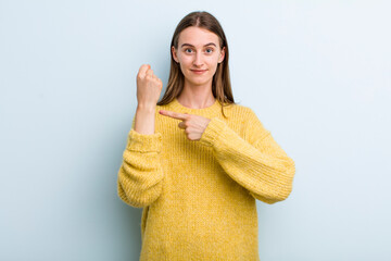 young adult pretty woman looking impatient and angry, pointing at watch, asking for punctuality,...