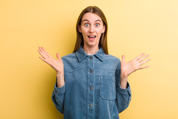 young adult pretty woman feeling happy, excited, surprised or shocked, smiling and astonished at...