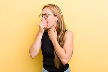 young adult  blonde woman feeling ill with a sore throat and flu symptoms, coughing with mouth...