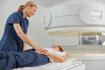 Radiologist controls MRI or CT Scan with patient undergoing procedure. High Tech medical equipment