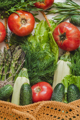 Reusable yellow crochet bag with fresh vegetable. Organic food and eco friendly shopping concept.