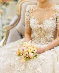 Bride sitting with a bouquet in the waiting room