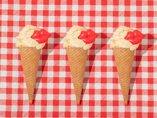 Summer creative pattern with ice cream cones with bright red lip figurines on red plaid background. 70s, 80s or 90s retro fashion aesthetic idea. Valentines day romantic idea.