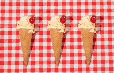 Summer creative pattern with ice cream cones and cherries on red plaid background. 70s, 80s or 90s retro aesthetic fashion idea. Minimal summer romantic idea.