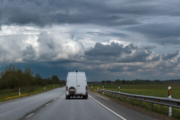 Fototapeta na wymiar Small truck driving on an asphalt road