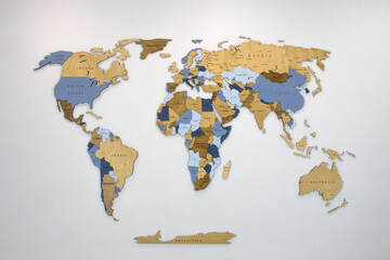 Fototapeta na wymiar Wooden color multilayer world map on a white wall.